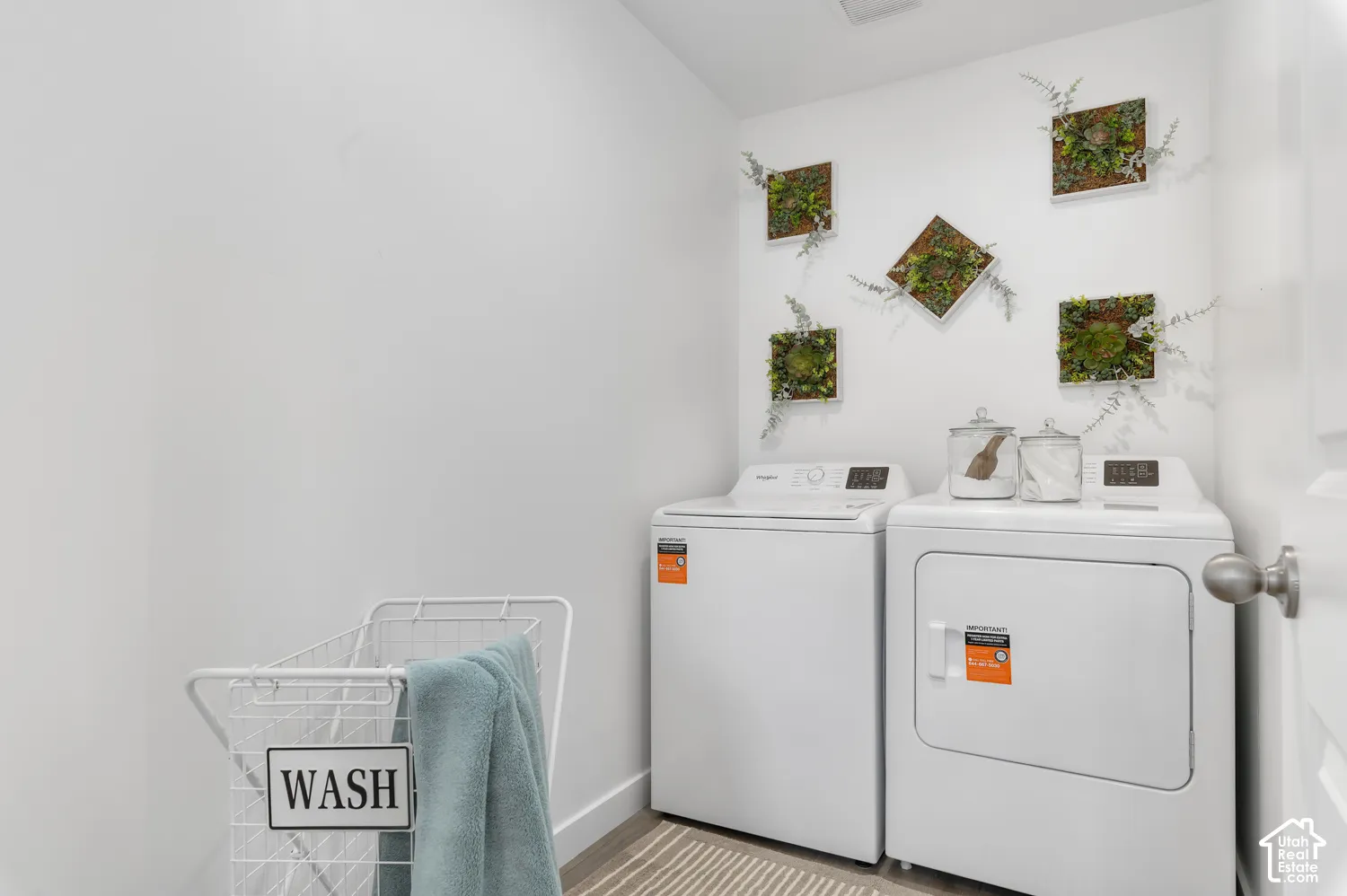 Laundry area featuring wood-finish flooring and neutral wall paint