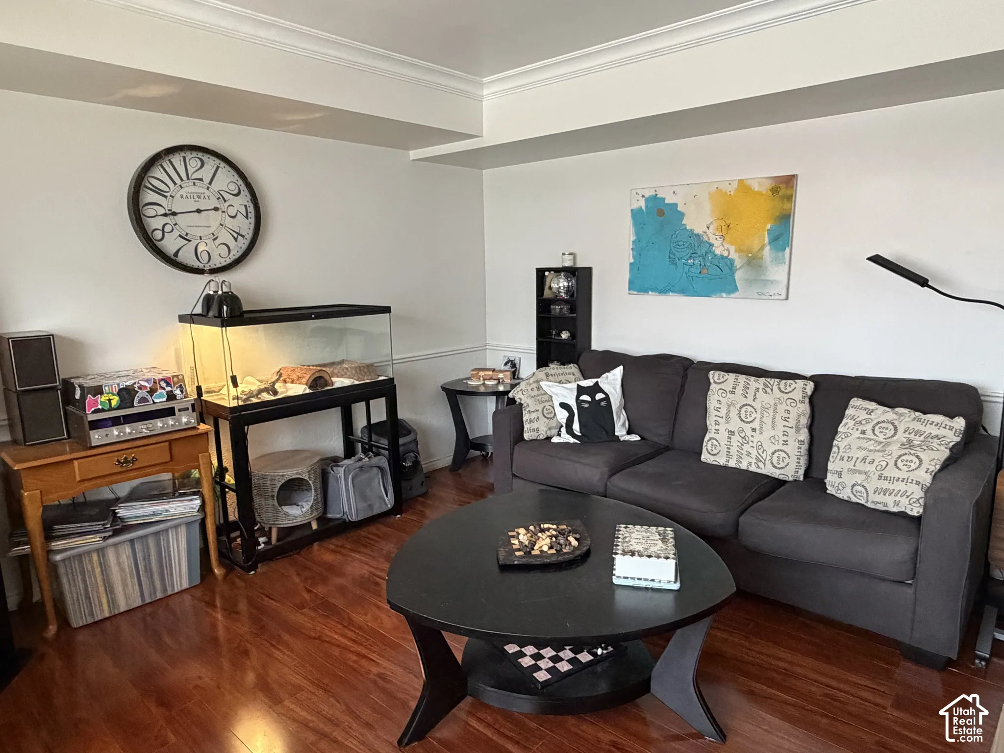 Living area featuring laminate flooring, crown molding, and wainscoting.