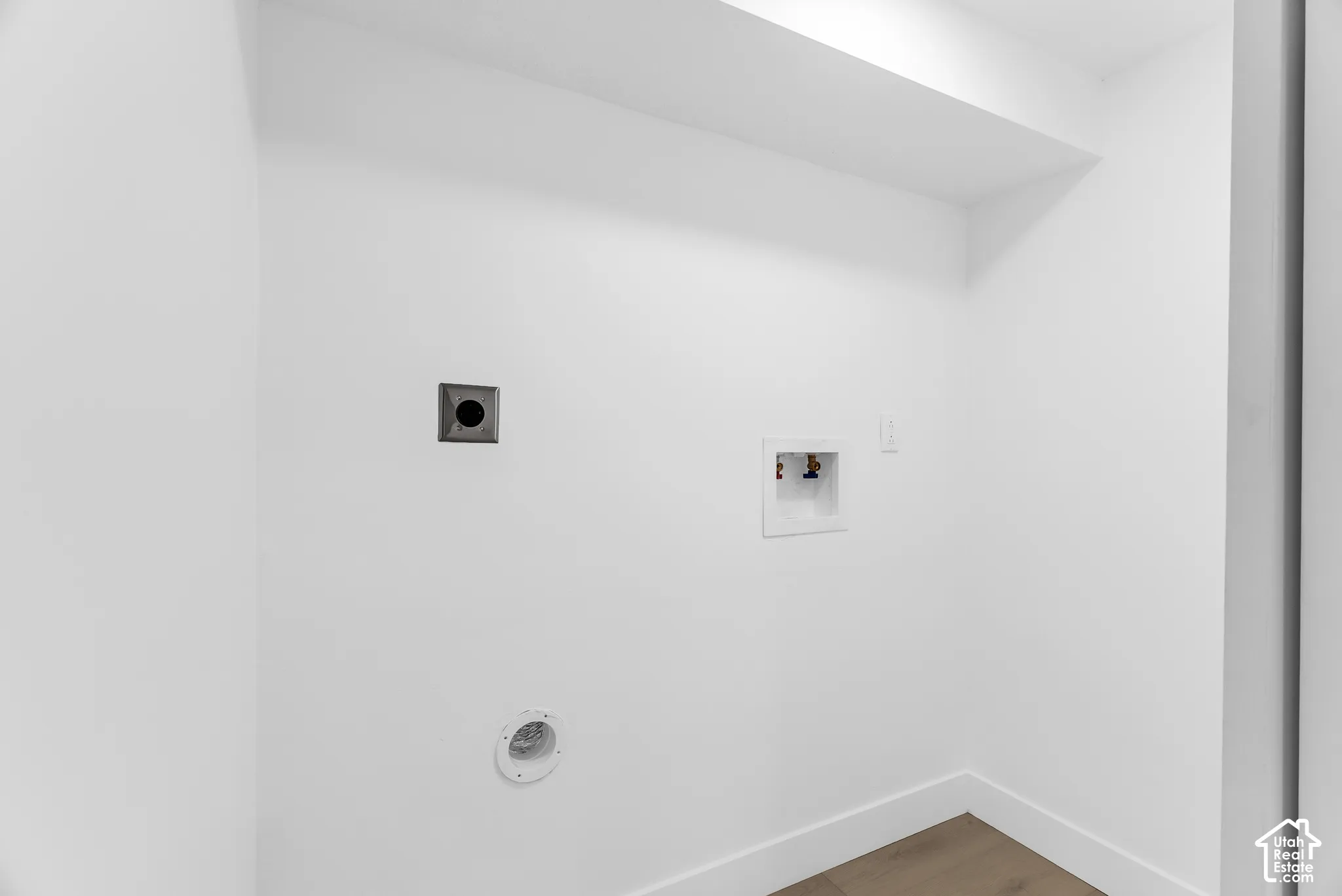 Dedicated utility space featuring washer and dryer hookups, recessed wall plumbing box, and exhaust vent