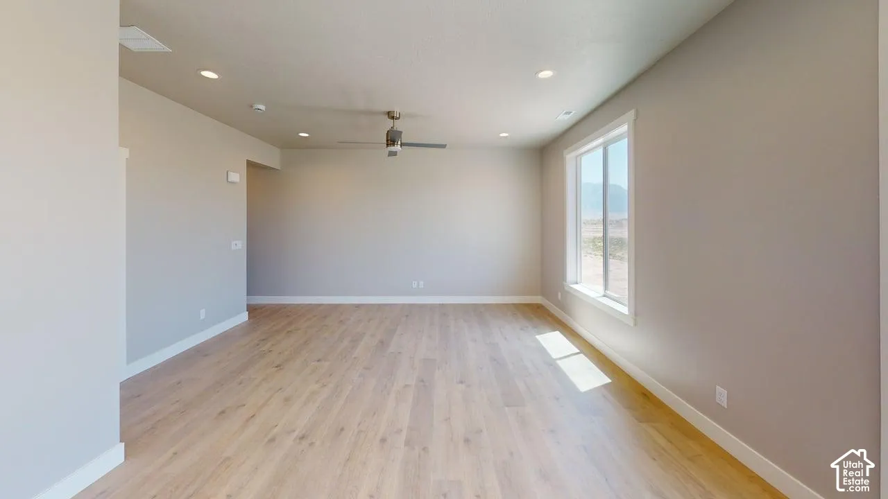 Neutral paint palette, wood-finish flooring, recessed lighting, and a ceiling fan