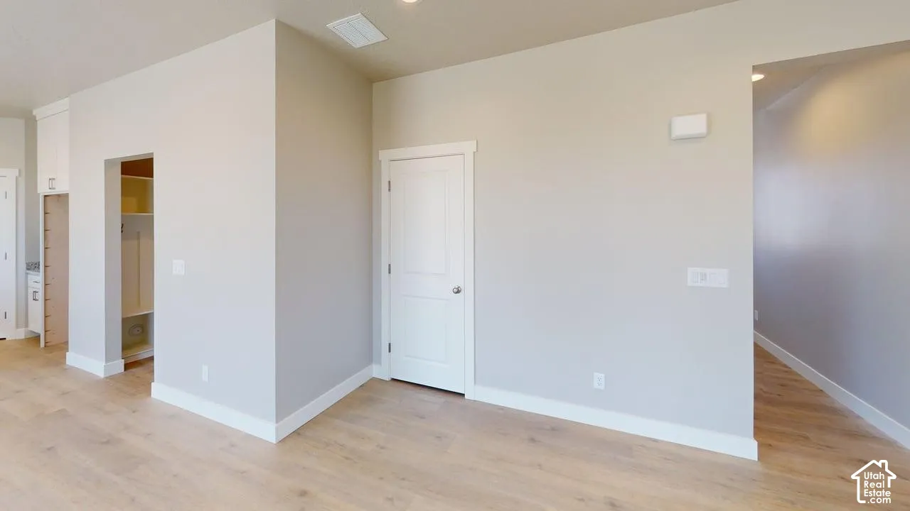 Interior space featuring wood-finish flooring, neutral wall paint, and white paneled doors