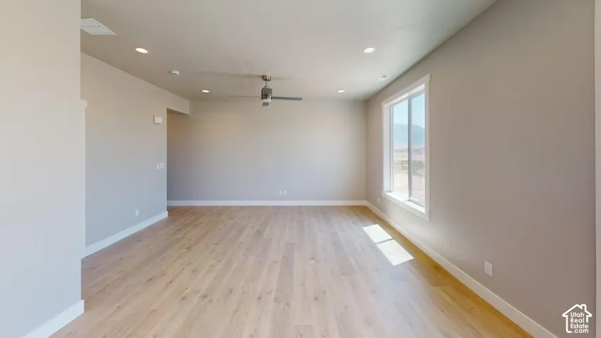 Neutral paint palette, wood-finish flooring, recessed lighting, and a ceiling fan