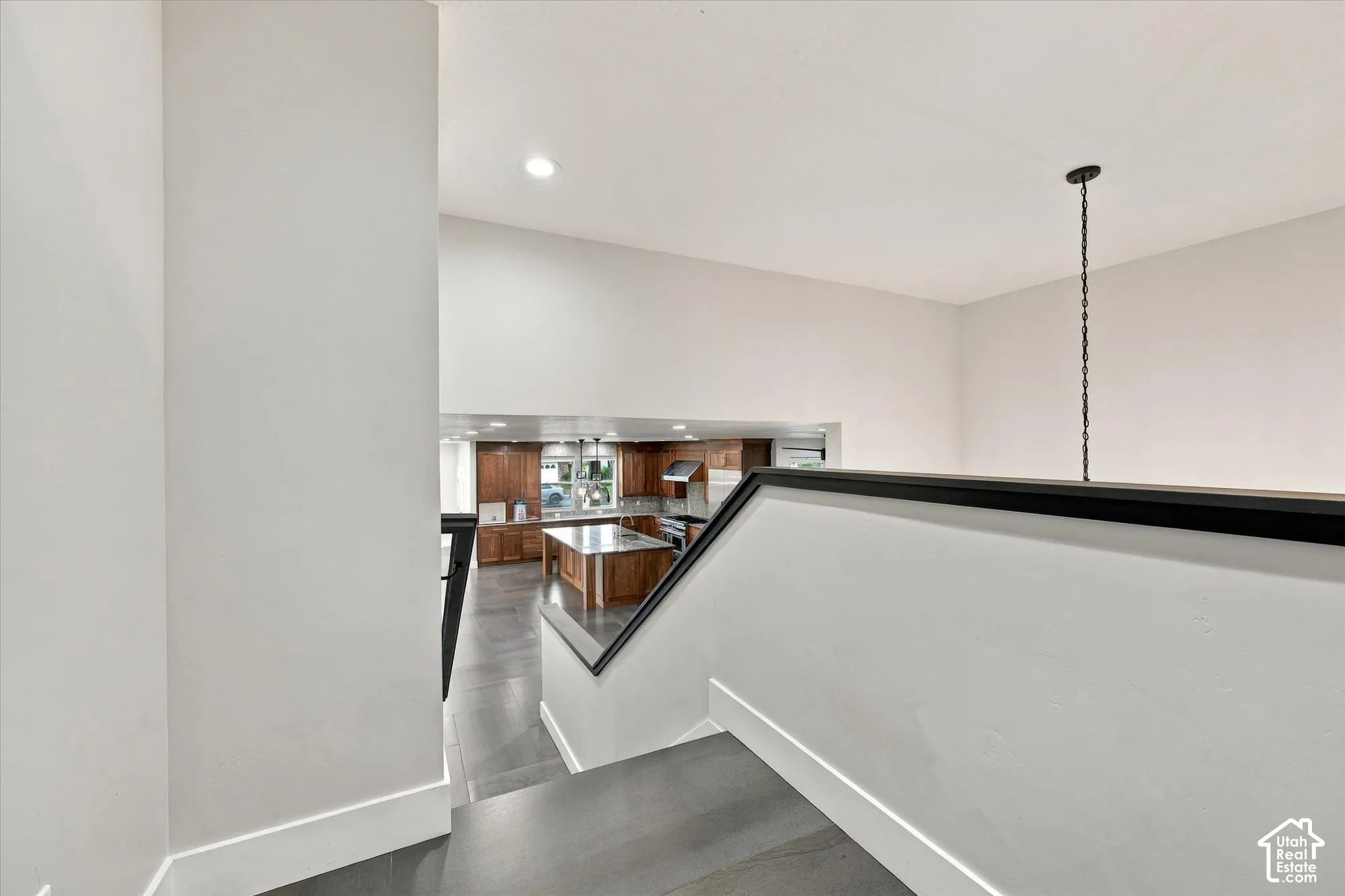 Vaulted ceilings, wood-finish flooring, recessed lighting, and a pendant light fixture