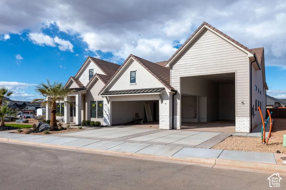 Modern exterior featuring multi-gabled rooflines, horizontal siding, stone veneer accents, and an expansive multi-bay garage structure