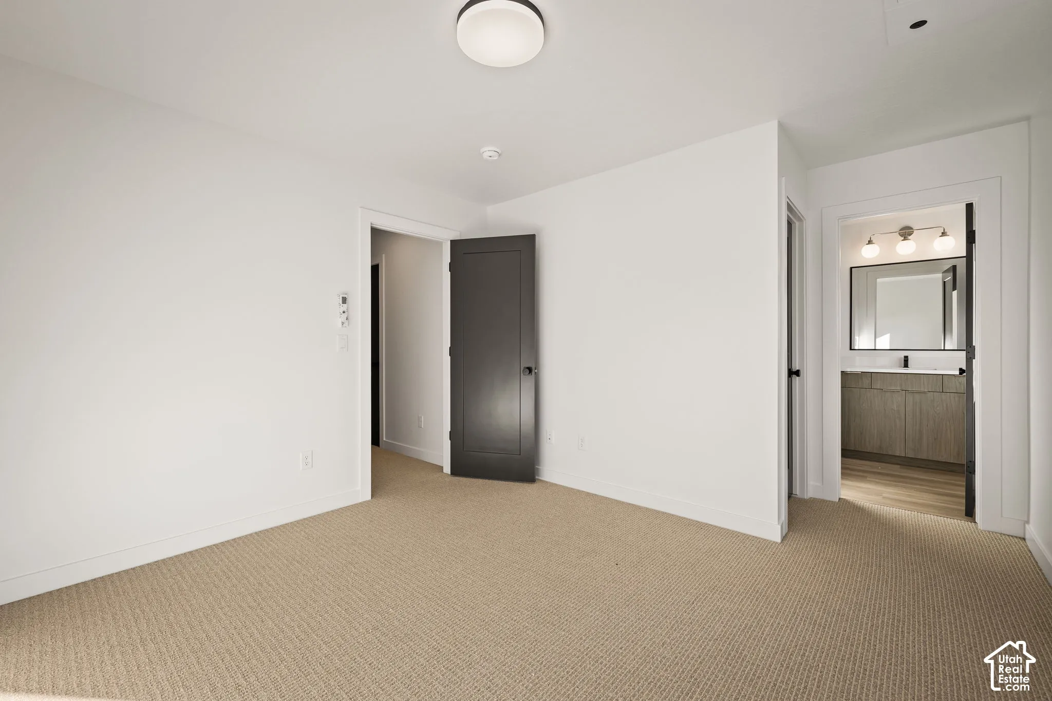 Neutral-toned carpeting, solid-core interior doors, recessed ceiling lighting, and crisp white wall finishes