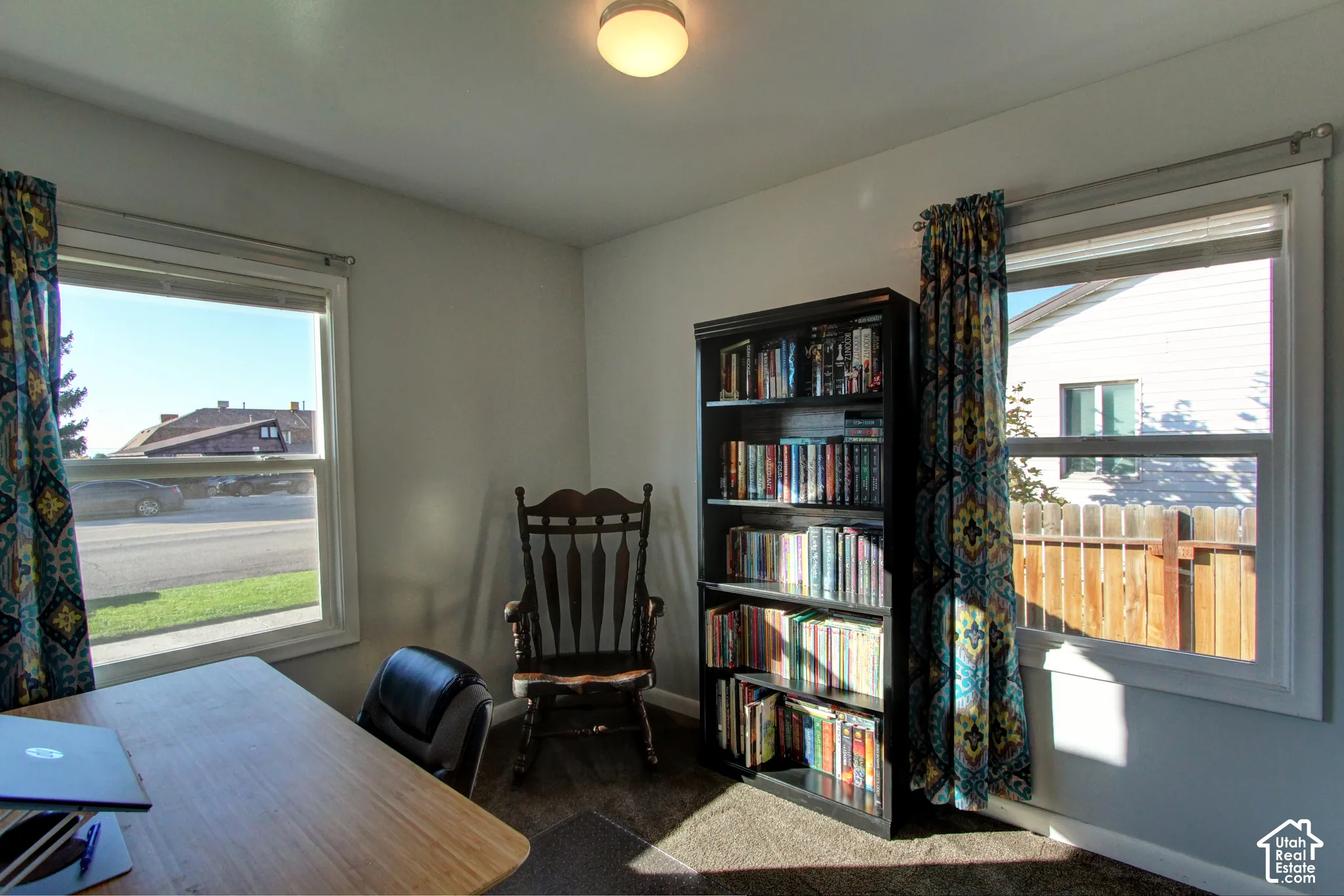 Room featuring dual windows with white casings, plush carpeting, and a central ceiling-mounted light fixture
