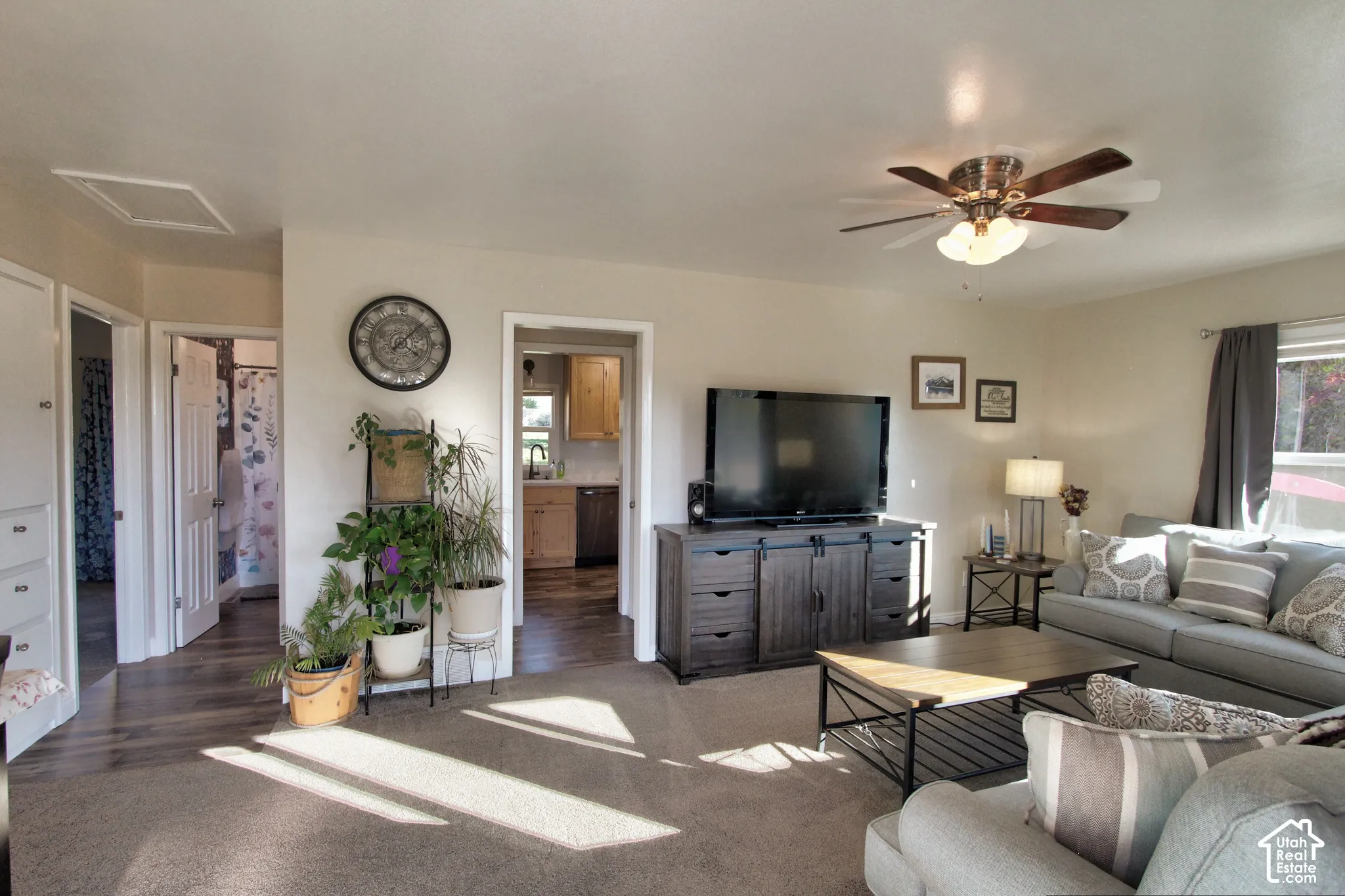 Living area featuring wall-to-wall carpeting, ceiling fan with integrated lighting, and multi-panel interior doors