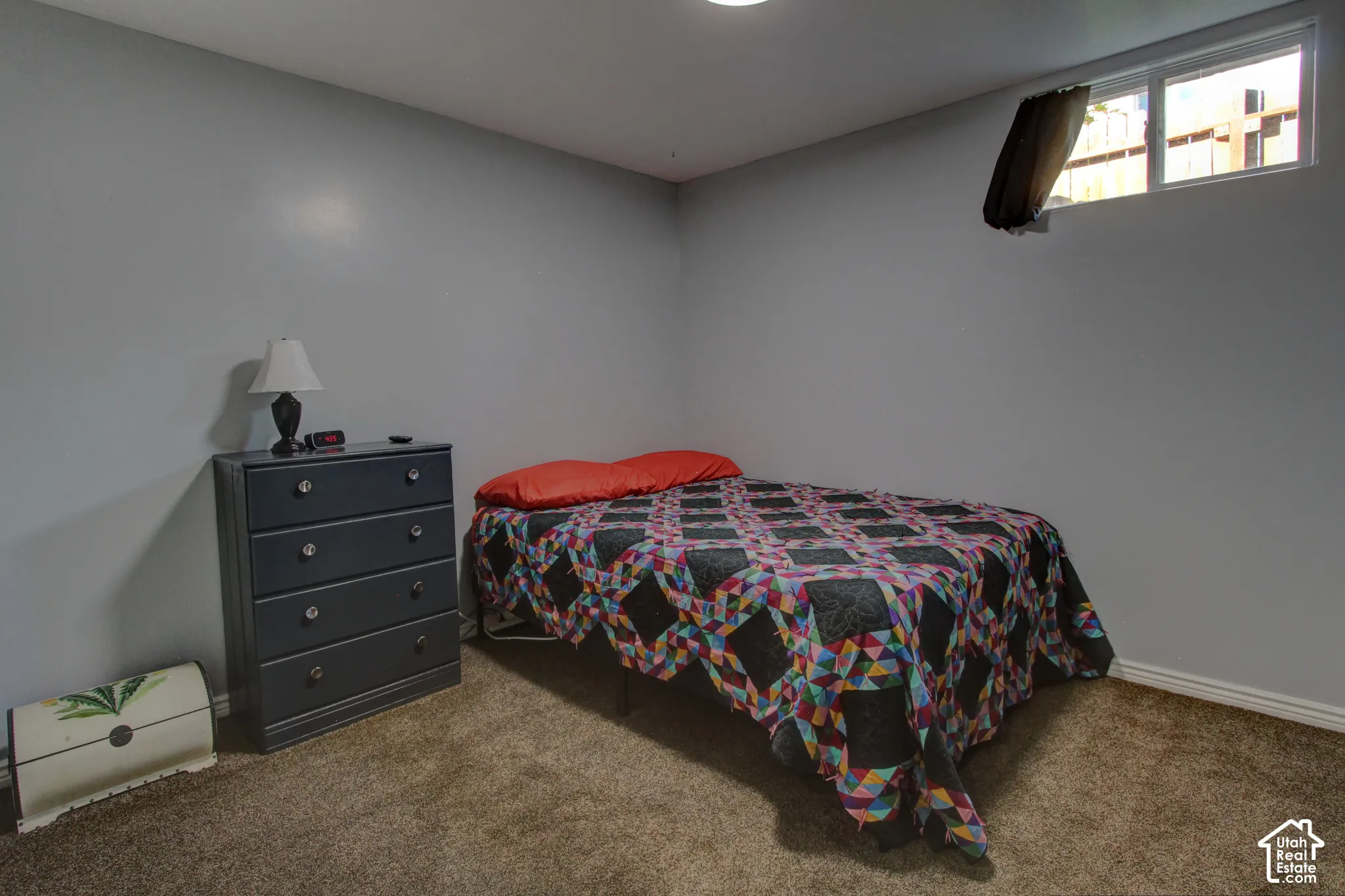 Neutral-toned walls, wall-to-wall carpeting, and a high-set horizontal window