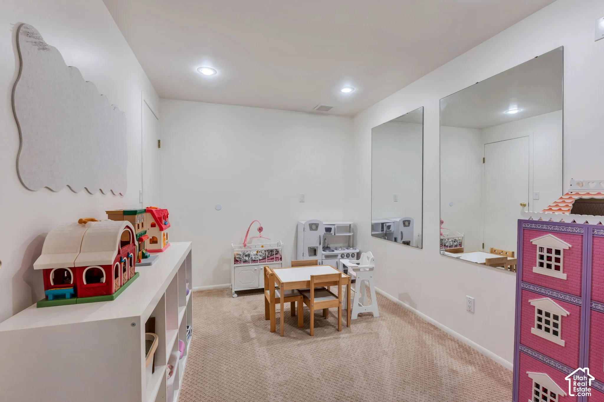 Room featuring neutral carpeting, recessed lighting, and wall-mounted mirrors