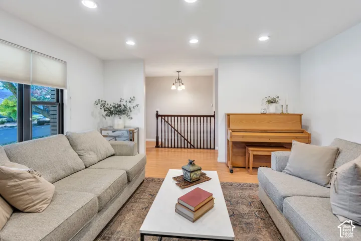 Interior space featuring recessed lighting, wood-finish flooring, and a dark wood staircase railing