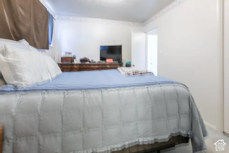 Room featuring neutral wall finishes, decorative crown molding, and a closet with a sliding door
