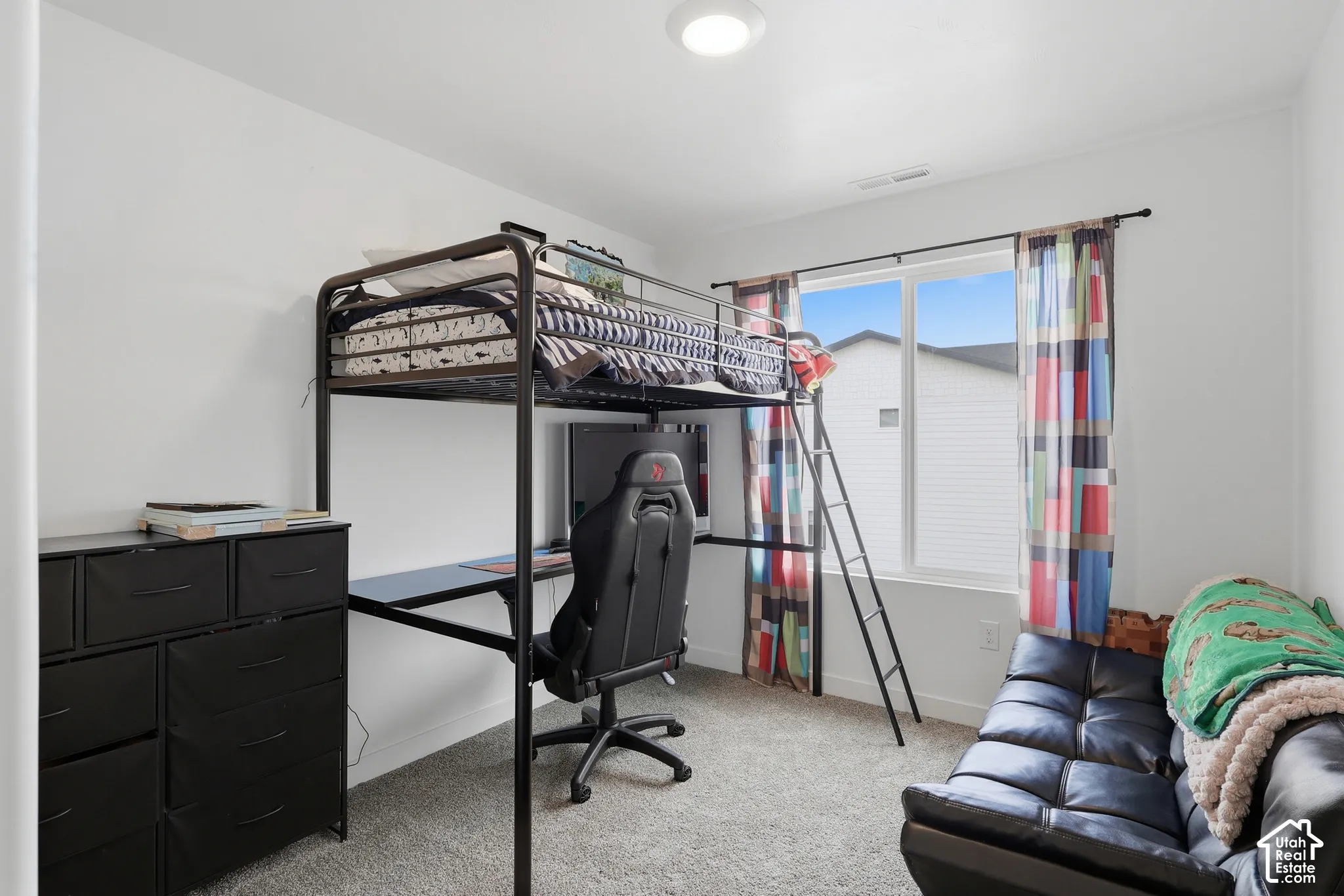 Bedroom with neutral wall paint, wall-to-wall carpeting, and a large window featuring a horizontal sliding sash