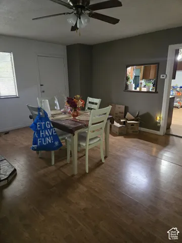 Wood-finish flooring, ceiling fan with integrated lighting, and an architectural wall cutout