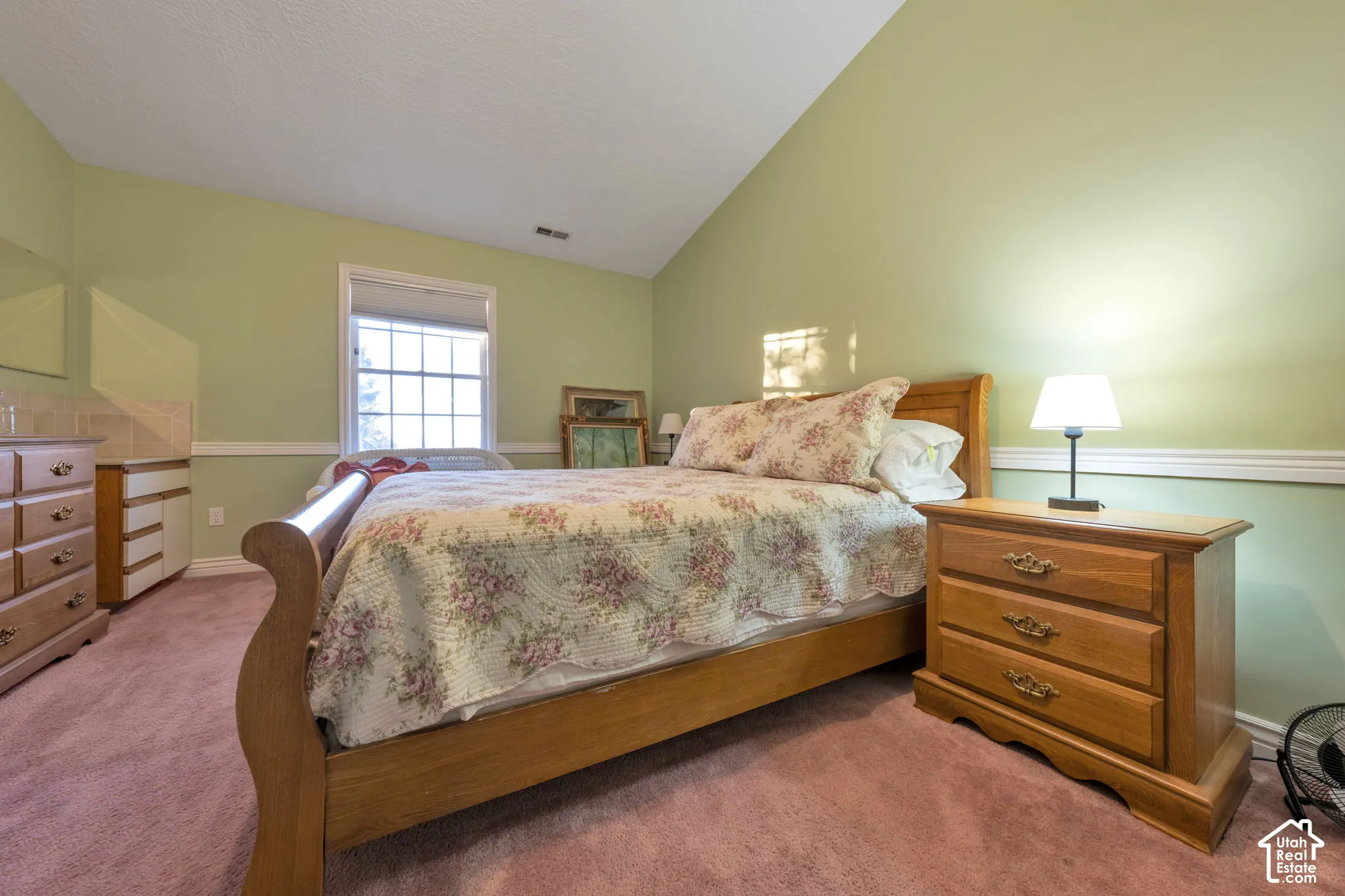 Vaulted ceiling featuring are in this third of 5 bedrooms, and has its own sink vanity.