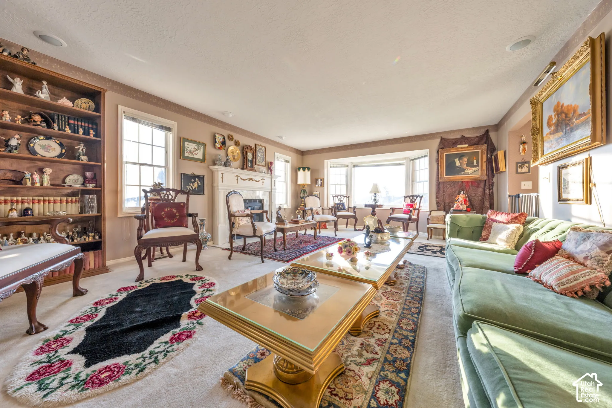 Spacious formal living room with abundant natural light, fireplace with a decorative mantel, and a bay window
