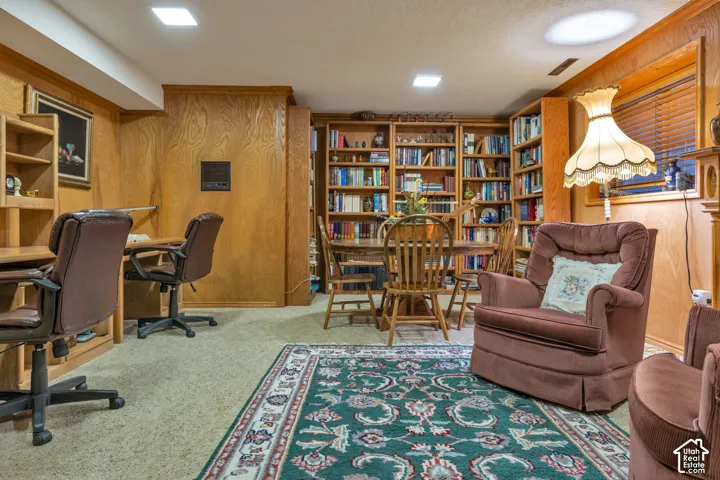 Wood-paneled walls, built-in floor-to-ceiling shelving, and integrated desk workspace featuring wood cabinetry and fireplace