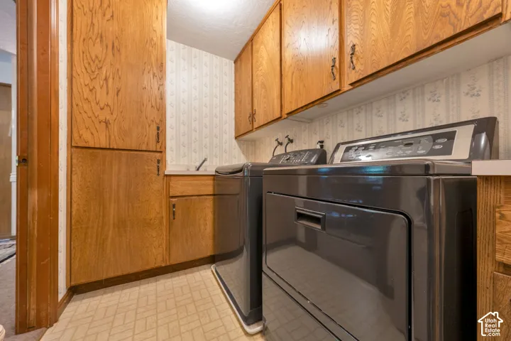 Built-in wood cabinetry, floor-to-ceiling storage, and integrated countertop sink. Lundry chute from the second floor delivers laundry directly to this room.