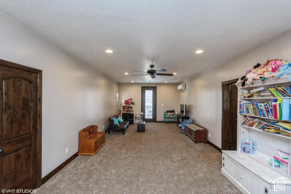 Interior space featuring recessed lighting, a ceiling fan, wall-mounted climate control unit, and wood-finish doors
