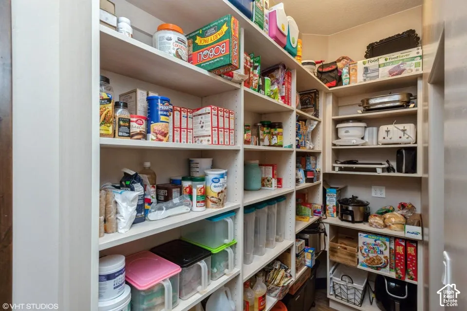 Walk-in pantry featuring built-in floor-to-ceiling adjustable shelving with high-capacity storage surfaces and corner-integrated cabinetry