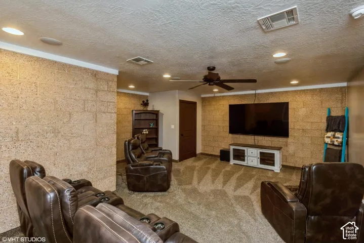 Textured masonry walls, recessed ceiling lighting, and a central ceiling fan