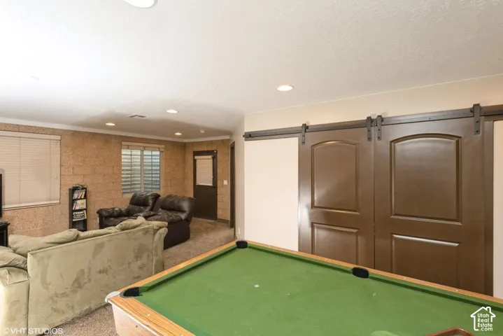 Textured masonry walls, recessed lighting, and double sliding barn-style doors with dark hardware