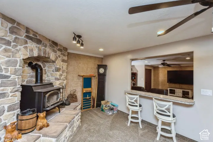 Stone-faced hearth featuring a black wood-burning stove and a raised stone platform
