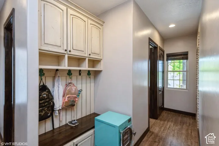 Built-in mudroom cabinetry featuring wood-finish bench seating, vertical paneling, integrated storage lockers, and overhead cupboards