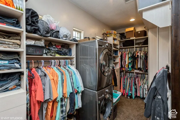 Custom storage space featuring built-in shelving, multi-level hanging rods, recessed lighting, and laundry hookups