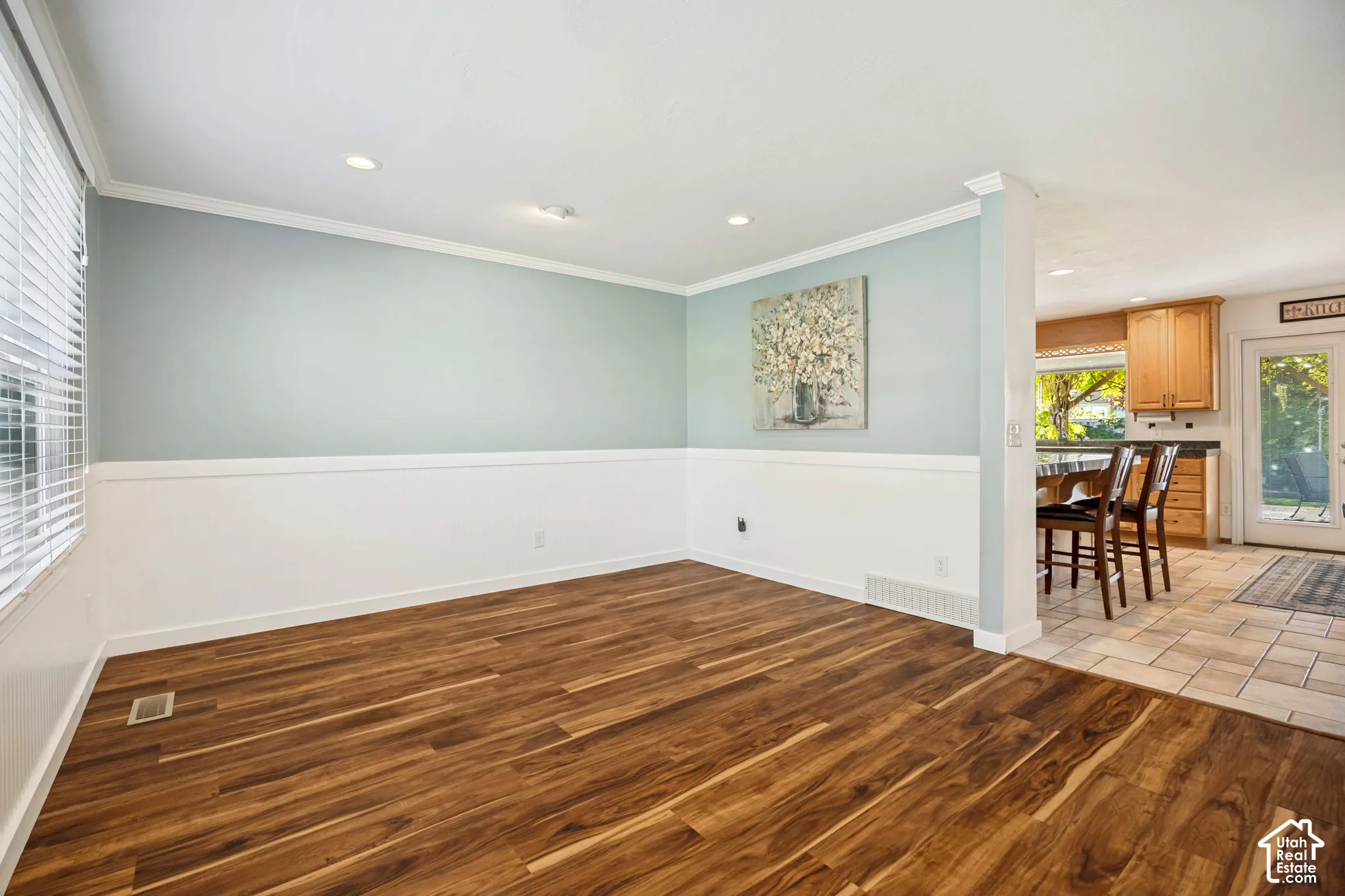 Wood-finish flooring, wainscoting, recessed lighting, and crown molding