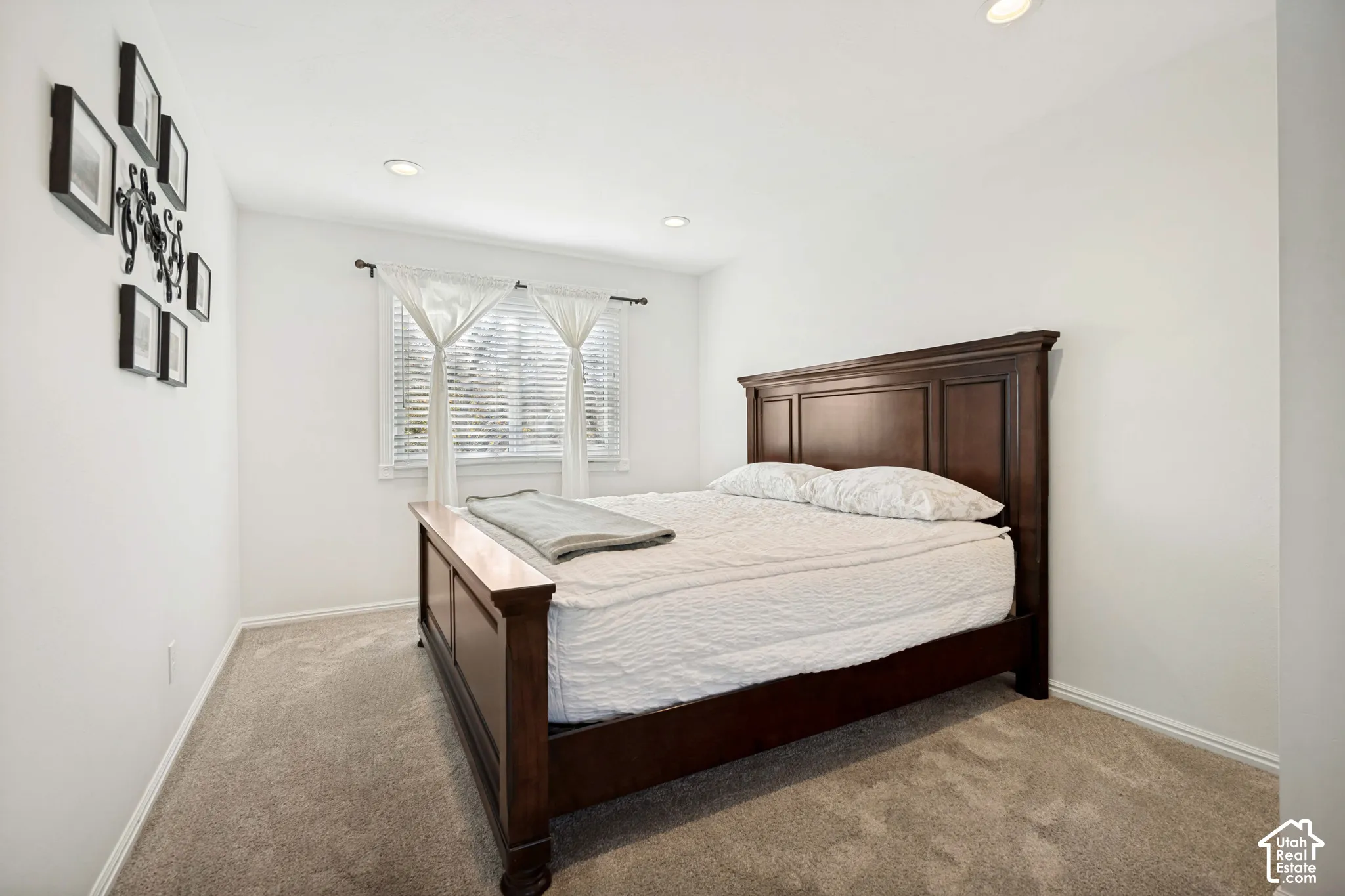 Room featuring neutral carpeting, recessed lighting, and a window with wood-blind fixtures