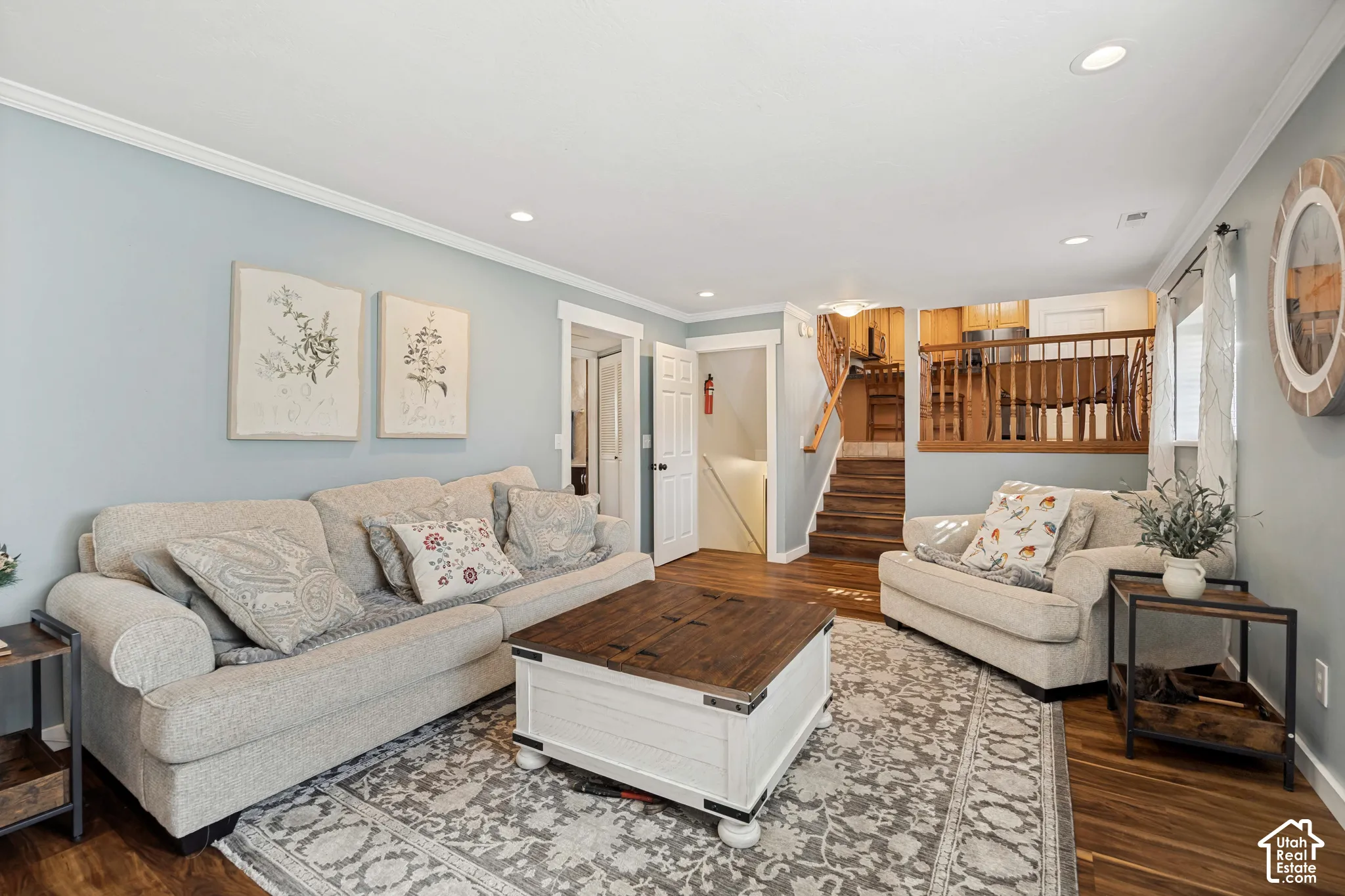 Living area featuring wood-finish flooring, recessed lighting, and wooden stair railings