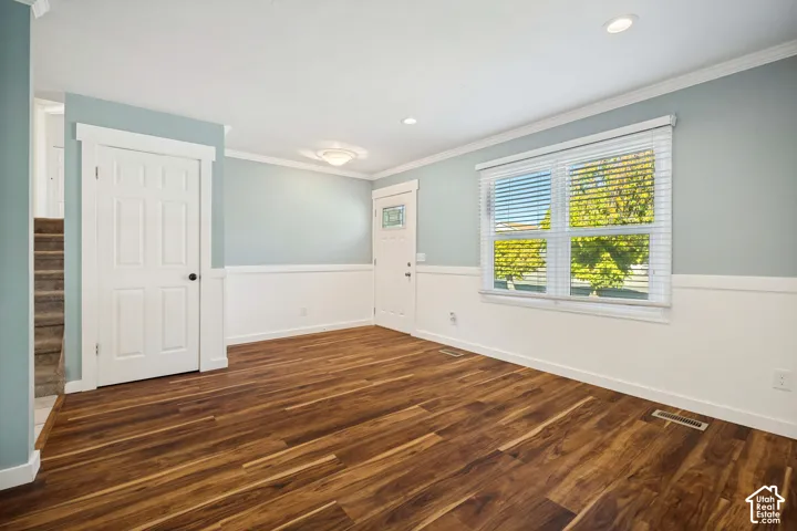 Interior space featuring wood-finish flooring, white wainscoting, recessed lighting, and a multi-pane window with horizontal blinds
