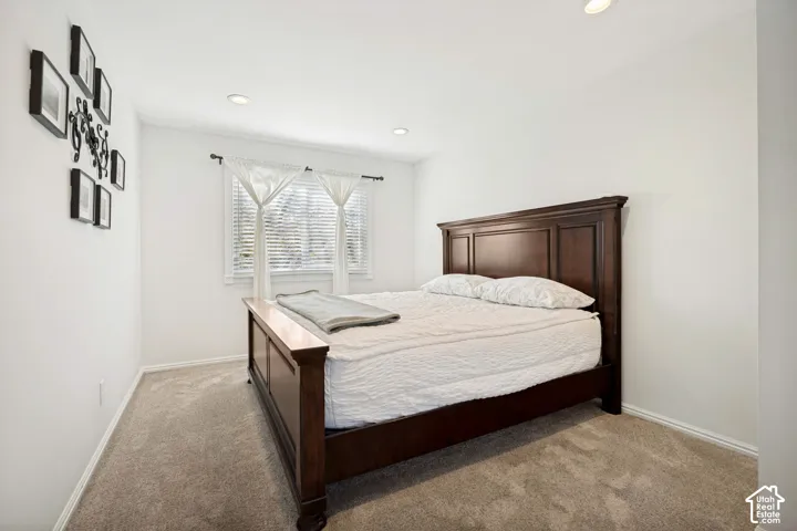 Room featuring neutral carpeting, recessed lighting, and a window with wood-blind fixtures