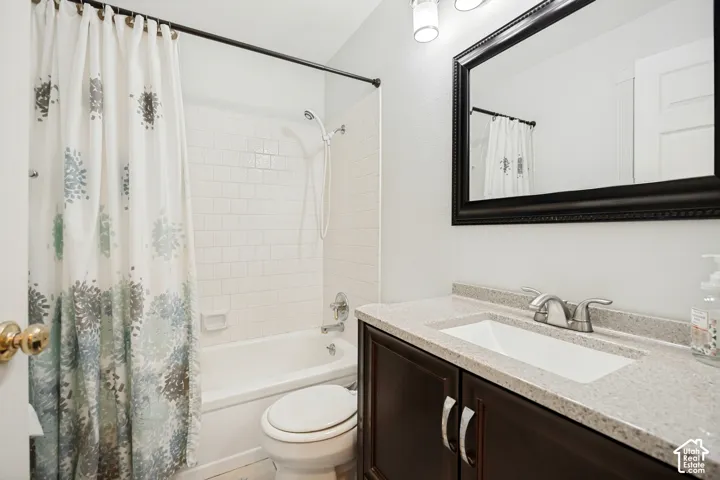 Bathroom featuring a vanity with a stone-composite countertop, integrated sink, dark wood-finish cabinetry, framed vanity mirror, and a tub-shower combination with subway-style wall tiling