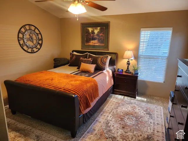 Room featuring carpeted flooring, window with horizontal blinds, and a ceiling fan with light fixture