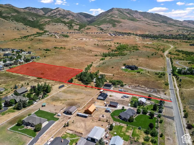 Aerial view of property's location featuring a mountain backdrop and rural landscape