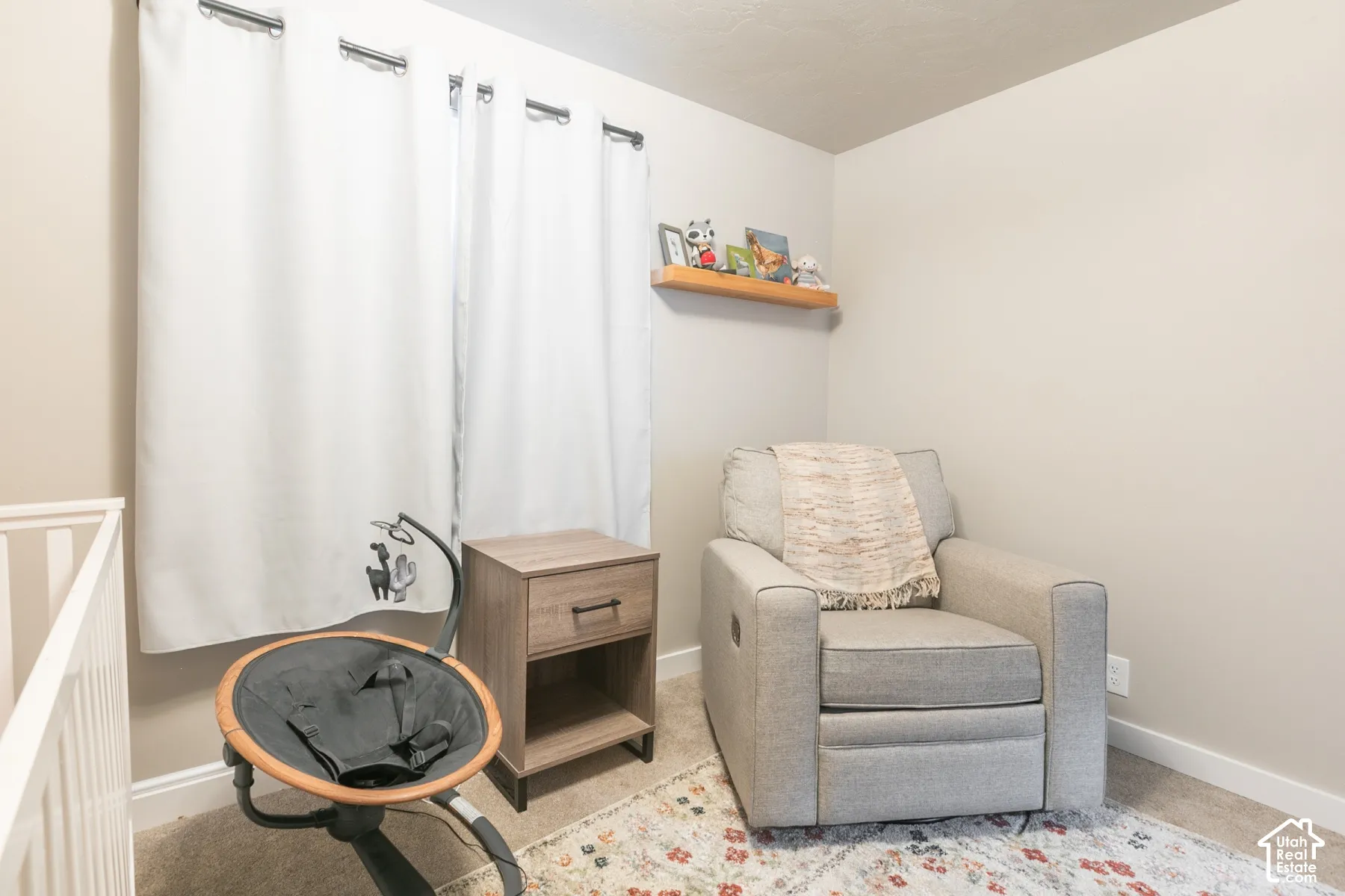 Wall-mounted floating wood shelf, neutral wall tones, and neutral carpeting