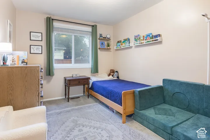 Neutral wall tones, carpeted flooring, and a large horizontal sliding window with white trim
