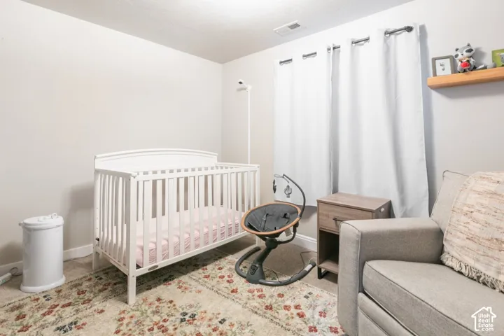 Neutral-toned room featuring a floating wood shelf, light-colored walls, and carpeting