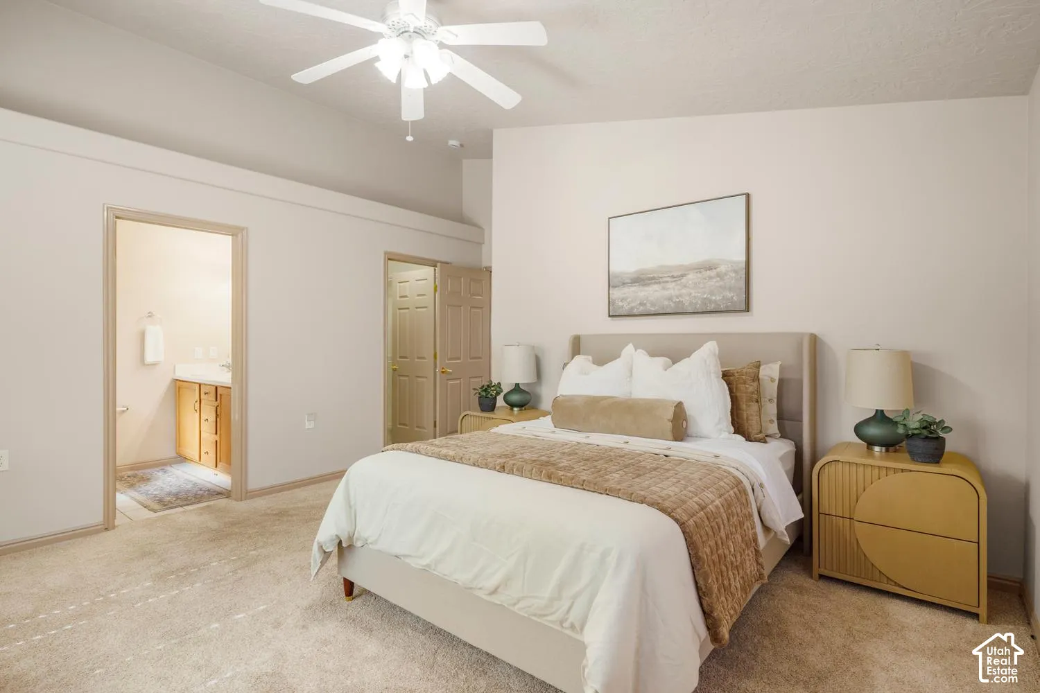 Vaulted ceiling with an integrated multi-blade ceiling fan, wall-to-wall carpeting, and neutral wall tones