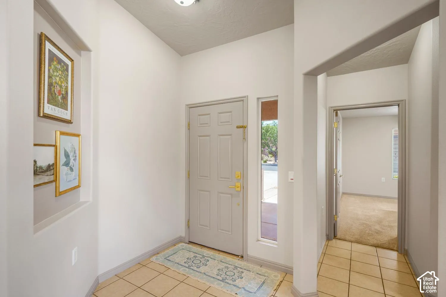 Foyer featuring neutral wall tones, ceramic tile flooring, a recessed wall niche, a paneled entry door, and a side light window