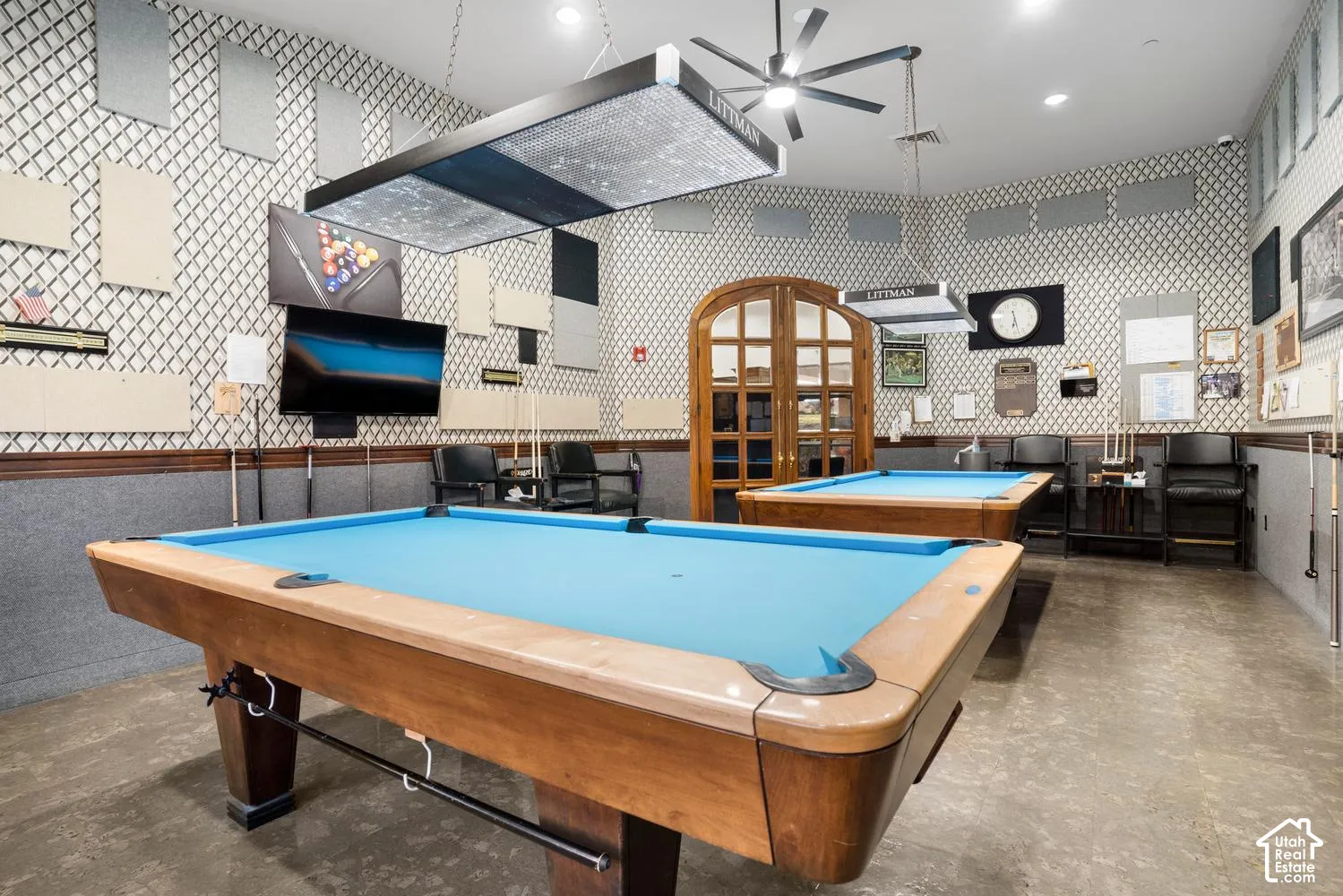 Geometric patterned wall treatment featuring acoustic panels, polished concrete flooring, arch-top French doors with glass panes, and custom pendant task lighting
