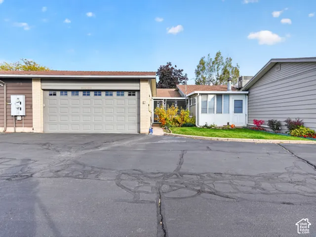 Exterior featuring a multi-car garage with a sectional door, mixed siding including horizontal lap and brick masonry, and asphalt driveway