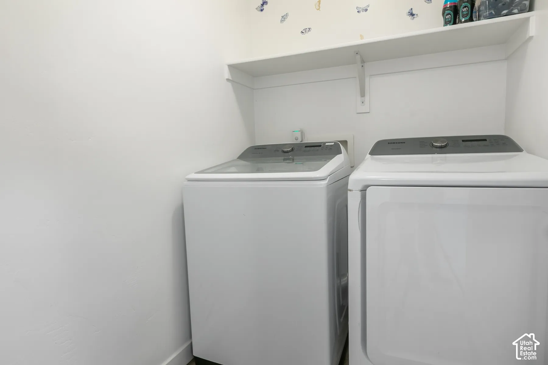Dedicated laundry area featuring a white built-in storage shelf and utility connections