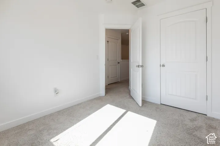Interior room featuring neutral-toned carpeting and two-panel arched interior doors with polished chrome hardware