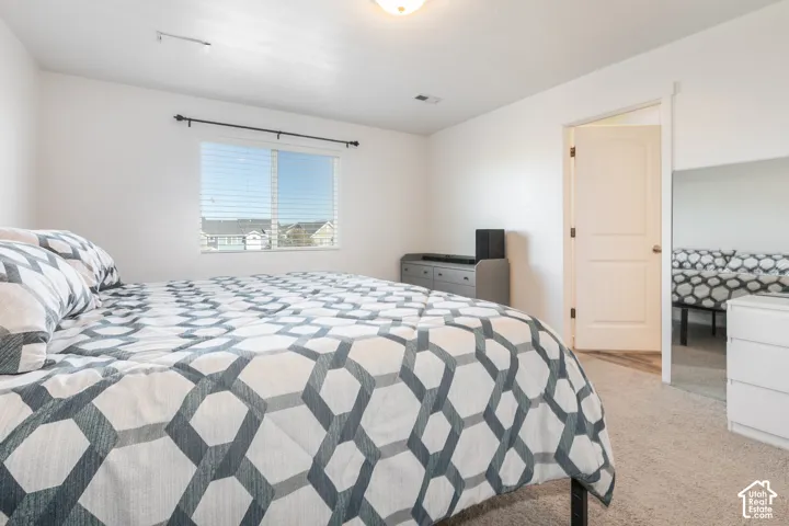 Neutral-toned carpeted flooring, white walls, and a multi-panel interior door