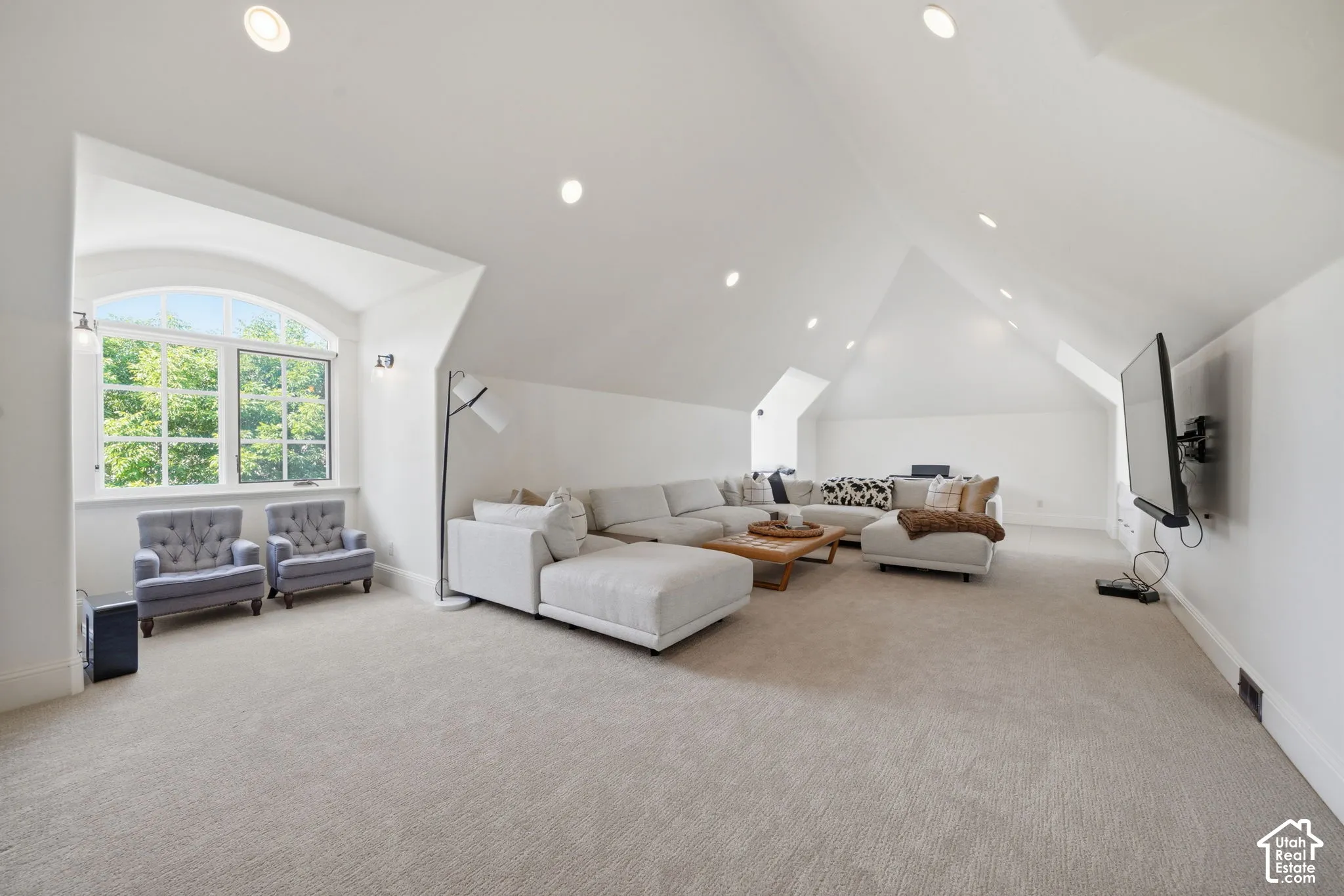 Vaulted ceiling featuring recessed lighting and a large arched window