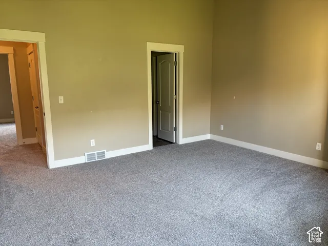 Room featuring neutral-tone walls, wall-to-wall carpeting, and high-profile trim around doorways