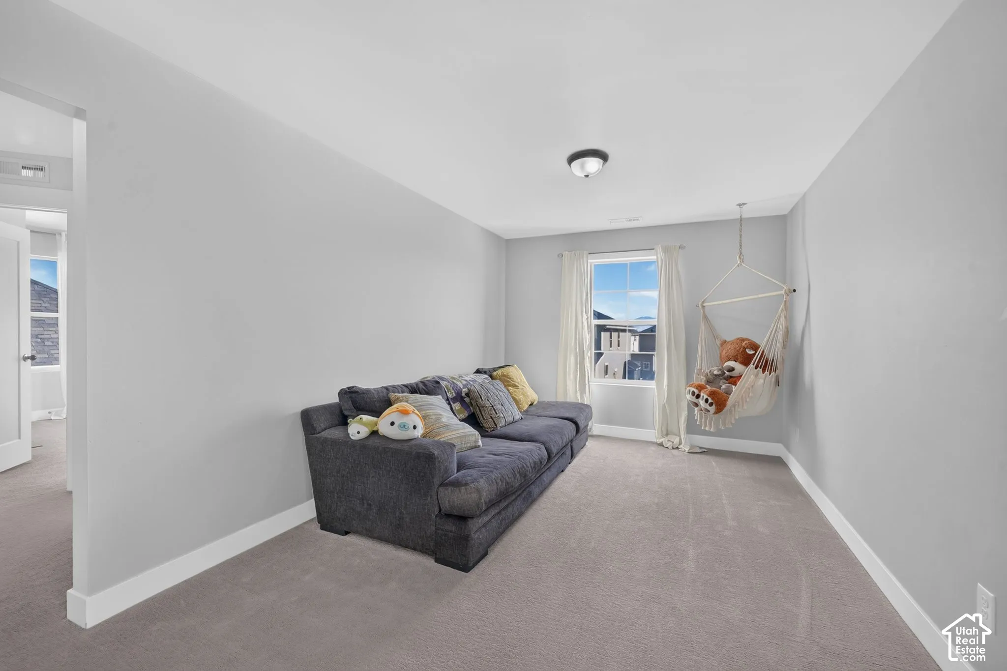 Neutral-toned room featuring neutral carpeting, light gray wall paint, and a single-pane window with a white frame