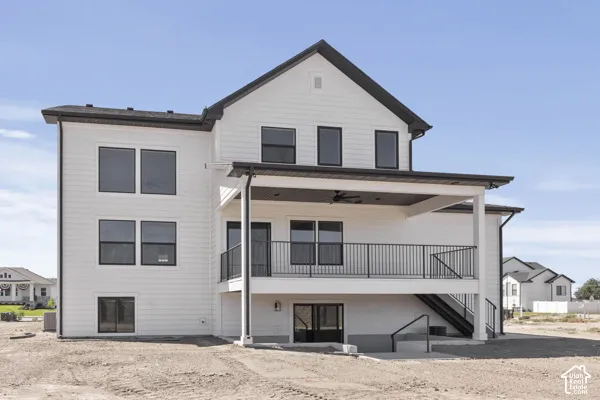 Two-story exterior with horizontal siding, covered rear deck featuring metal railings, recessed ceiling lighting, and exterior staircase